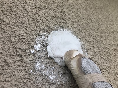 二階の部屋の窓から身を乗り出してパテを埋め込む