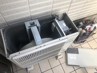 上蓋を外して室外機内部を点検している画像